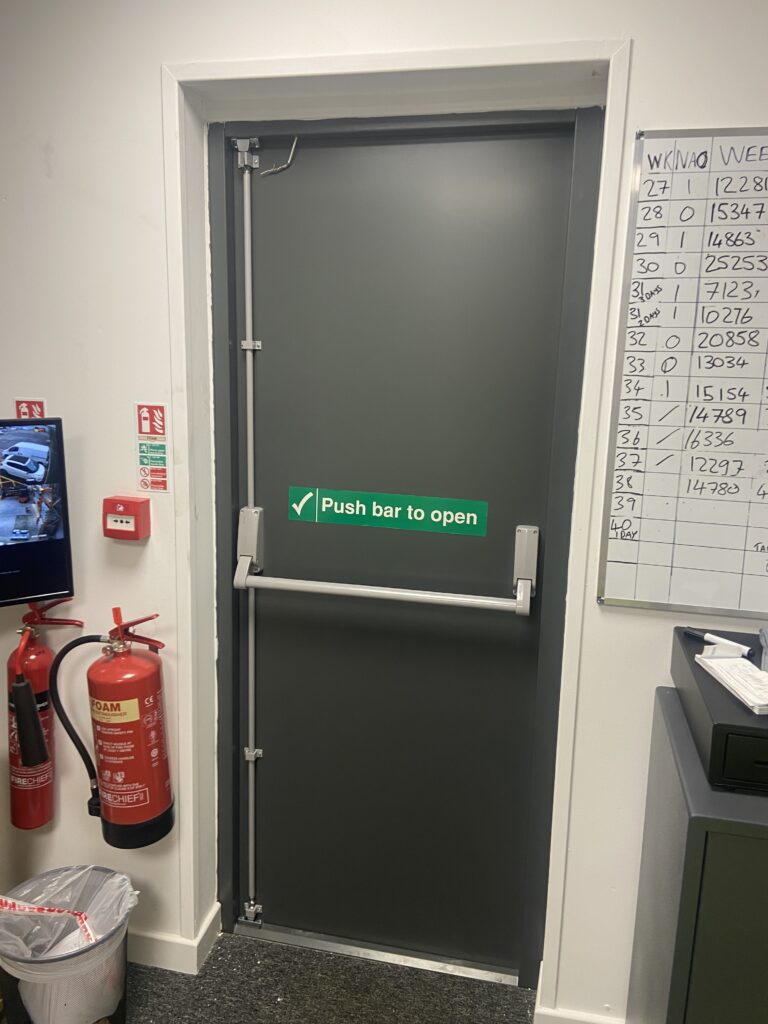 A steel fire exit door as seen from within a building